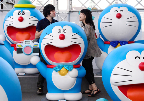 2013年9月3日，在日本东京举行的一个展览上，游客欣赏哆啦A梦玩偶。图片：新华社/法新